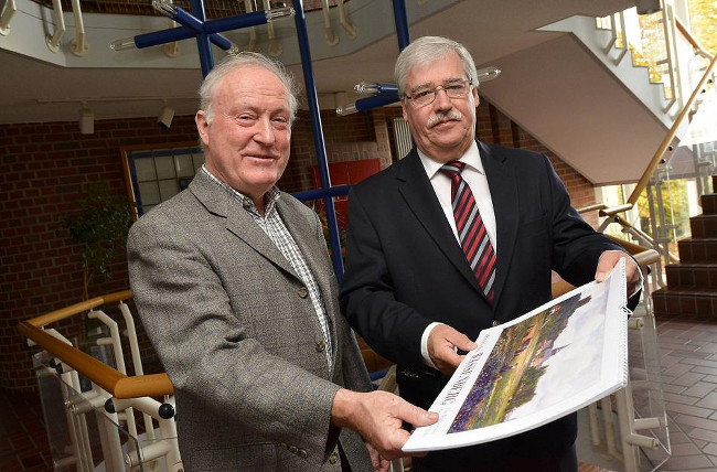 Heimatvereinsvorsitzender Sepp Becker (li.) übergibt Bürgermeister Manfred Winkens einen der druckfrischen Bildkalender. FOTO: Jörg Knappe